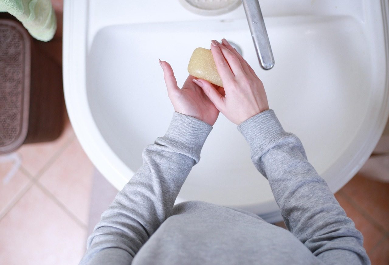 Miska s ranní ovesnou kaší, ovocem a semínky na dřevěném stole u okna